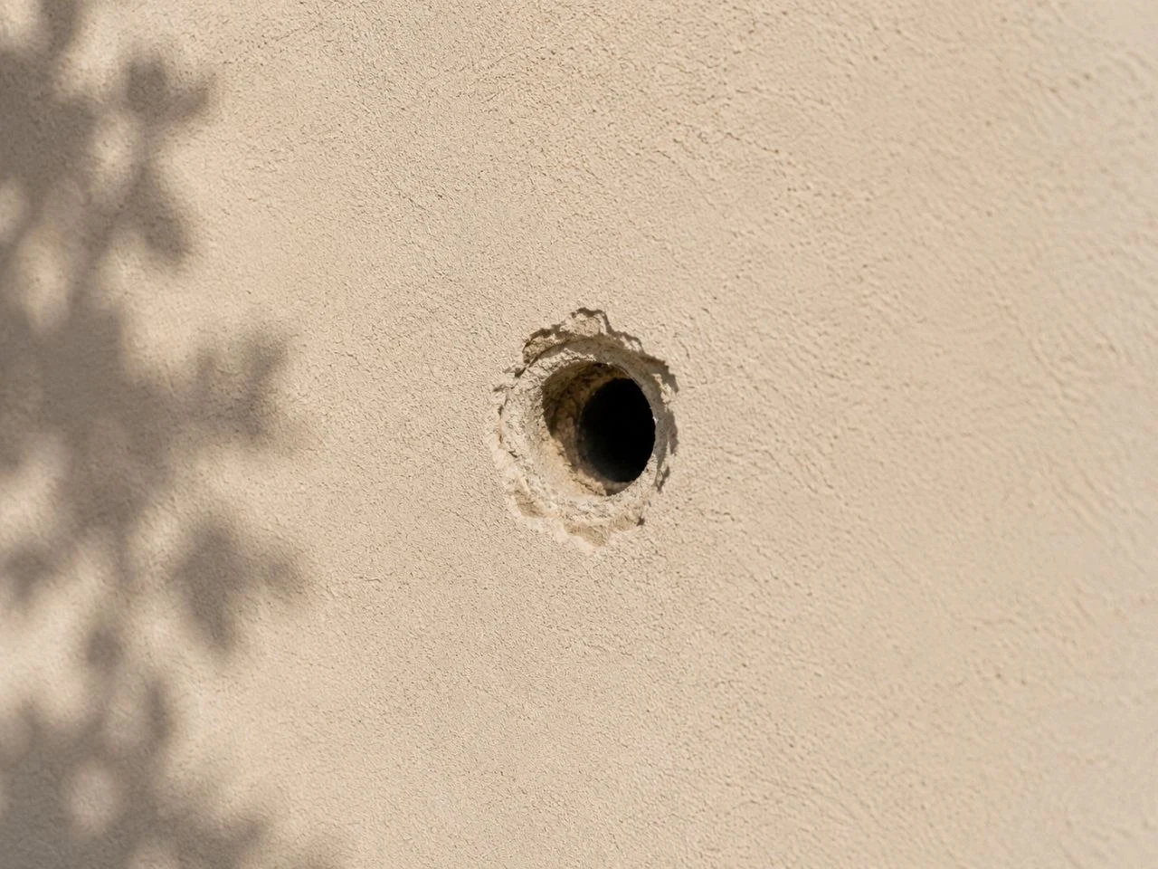 Small circular hole in stucco